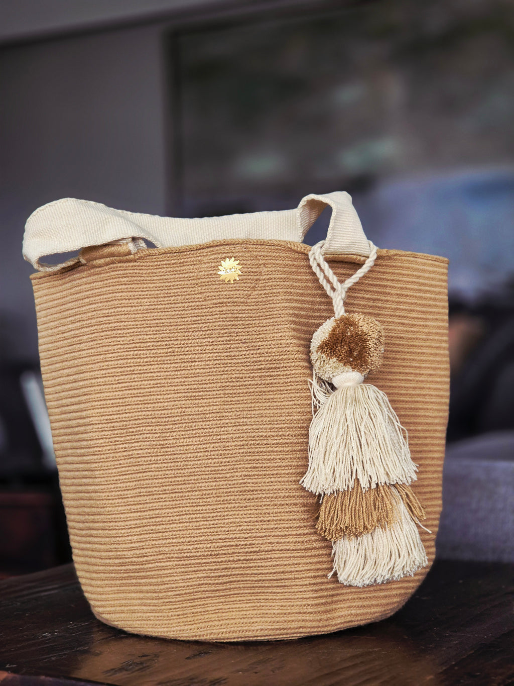 Dark beige handbag with light beige handle and light and dark beige pompom