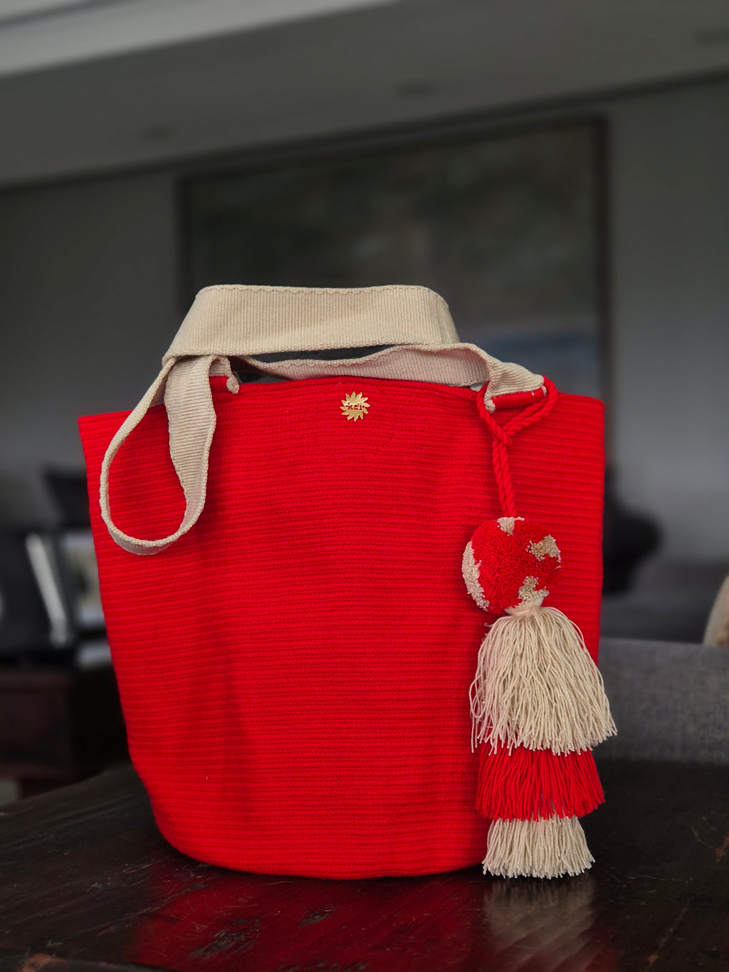 Cartera roja con asa beige y pompón beige y rojo
