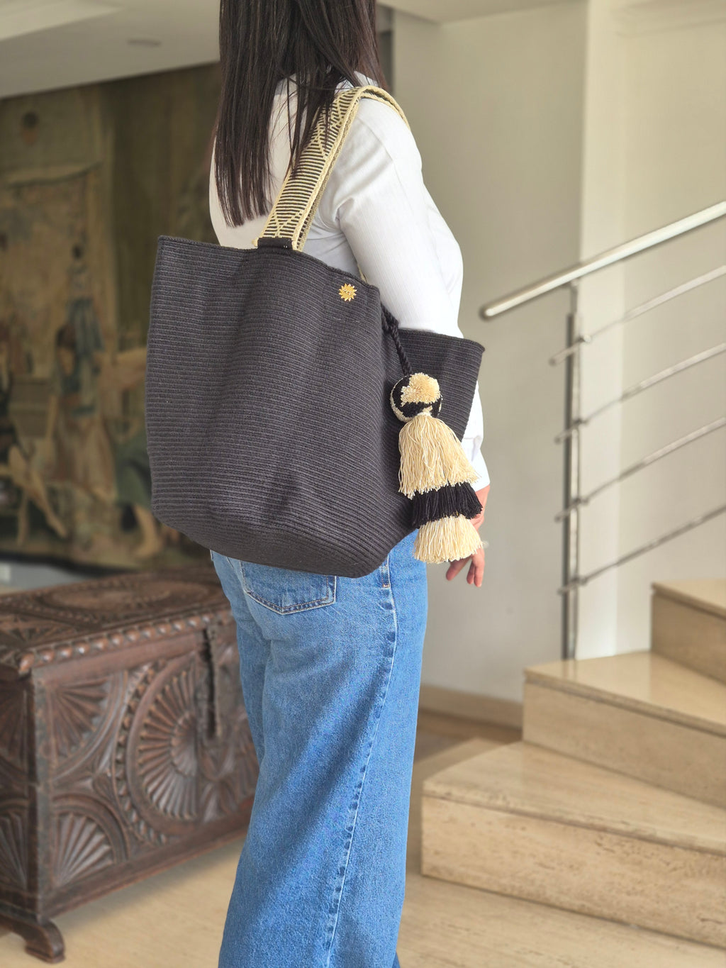 Black handbag with handle and pompom in black and beige