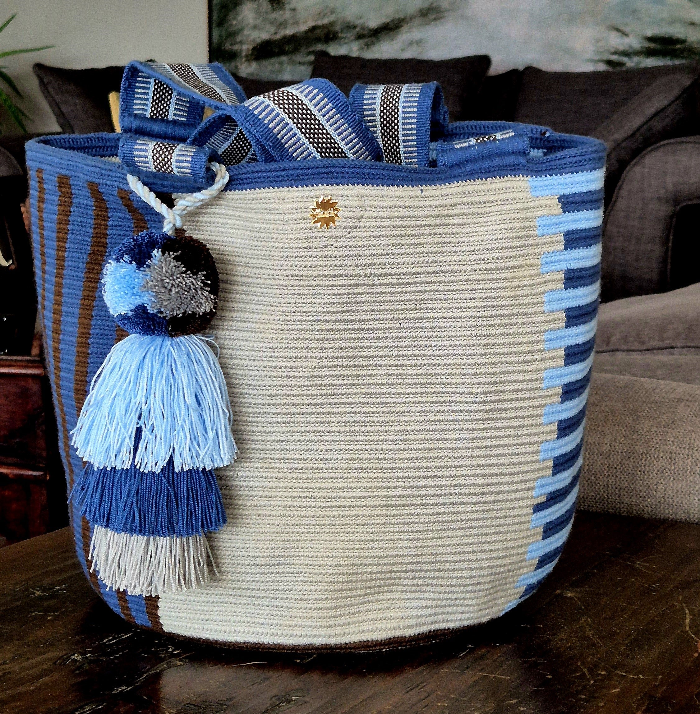Cartera gris con lineas horizontales azul turquesa y marino, lineas verticales marrón y azul marino