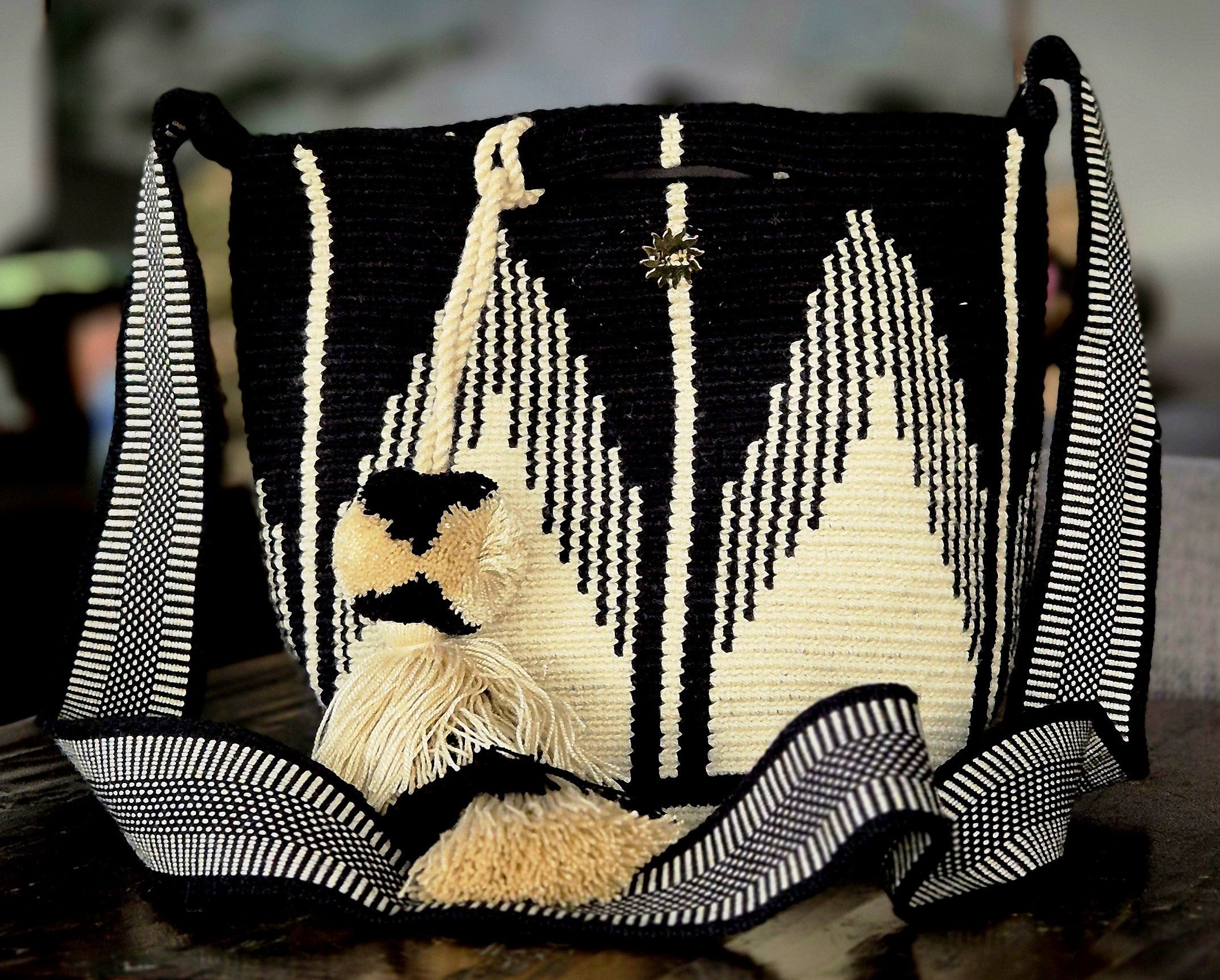Bag with beige triangles at the base intertwined with inverted black triangles from the top