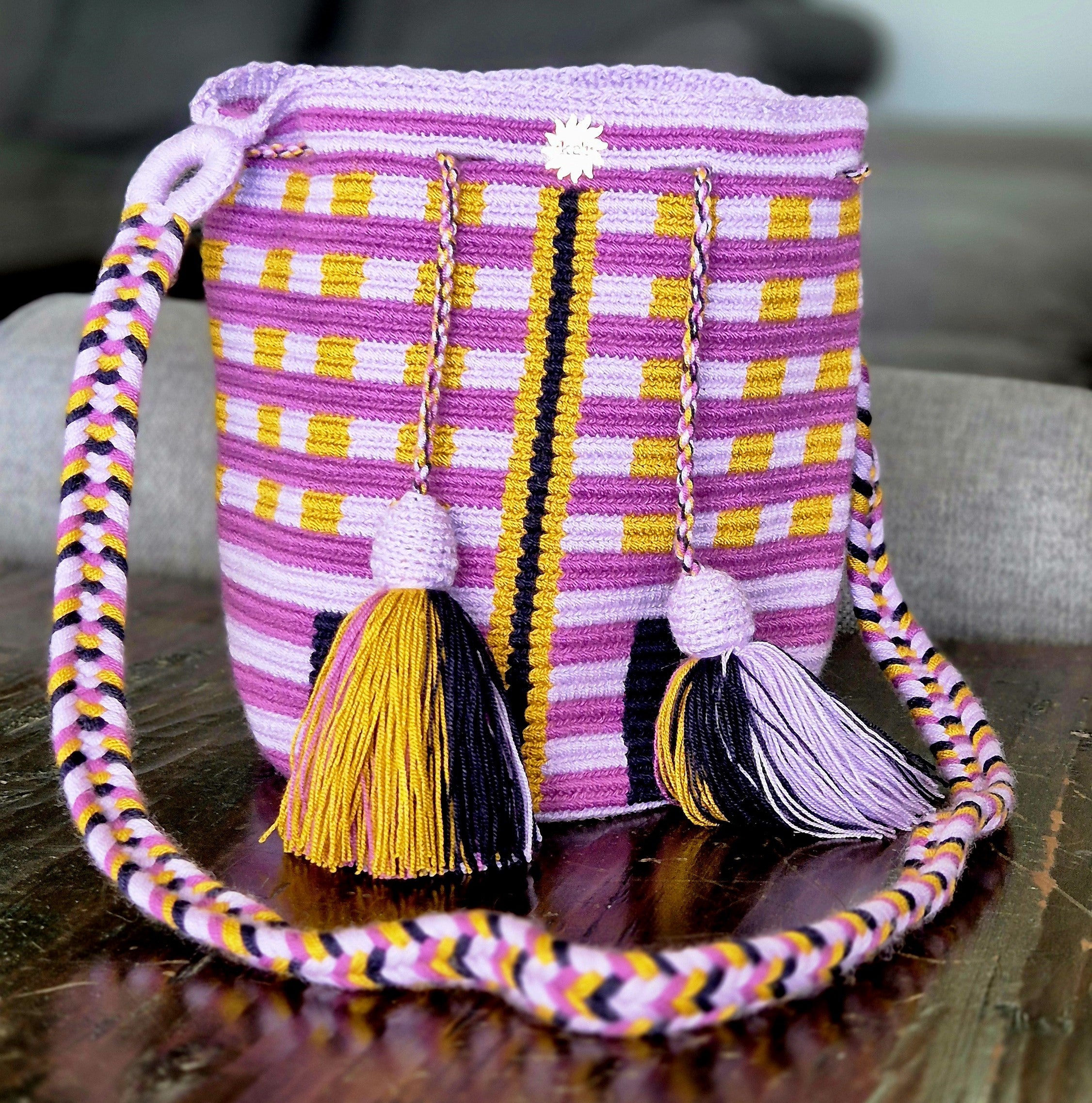 Violet bag with horizontal purple and vertical mustard lines, black rectangles at the base