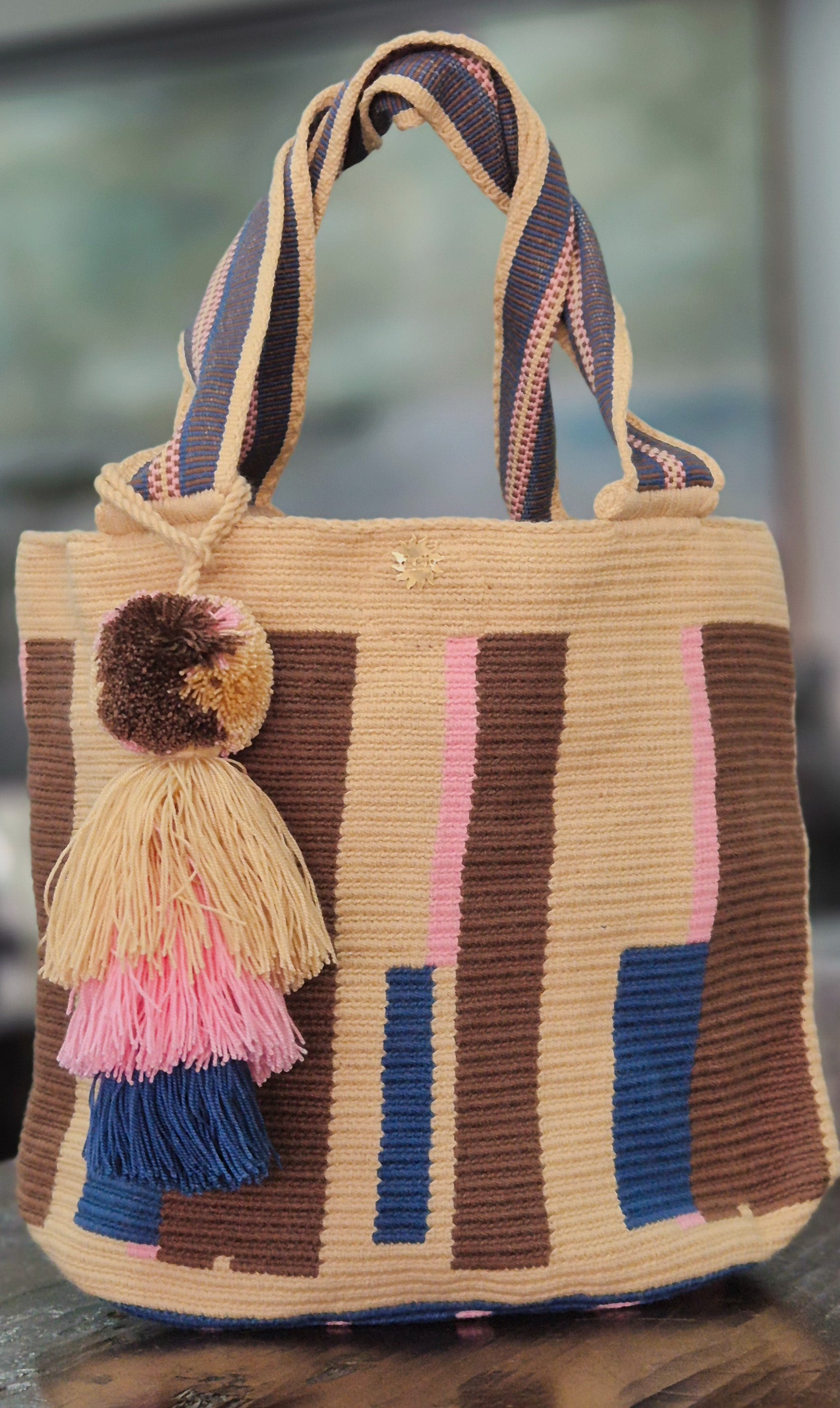 Cartera beige con barras marón, rosadas y azul electrico