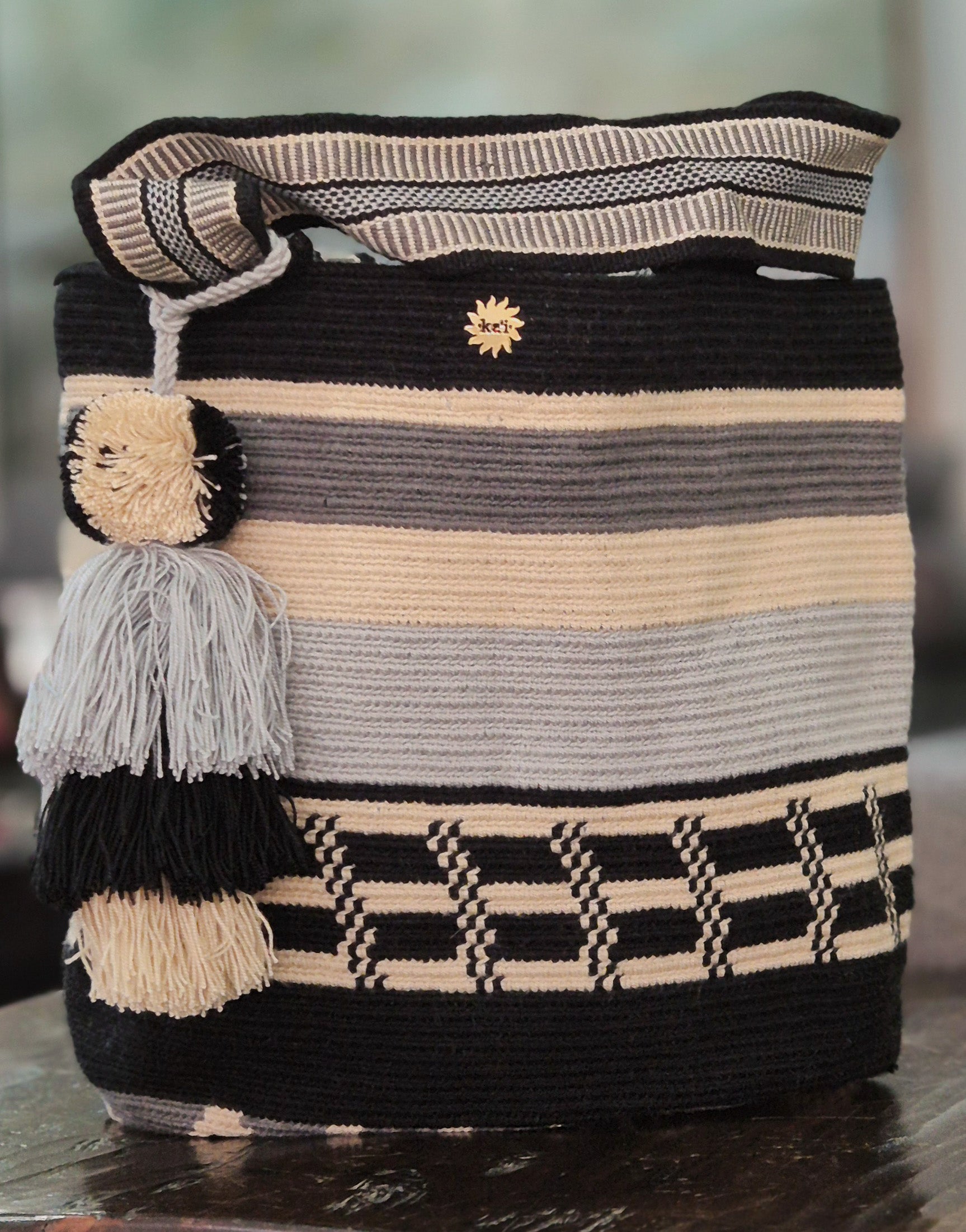 Cartera a bandas negro, gris, beige y azul claro con pixeles negros