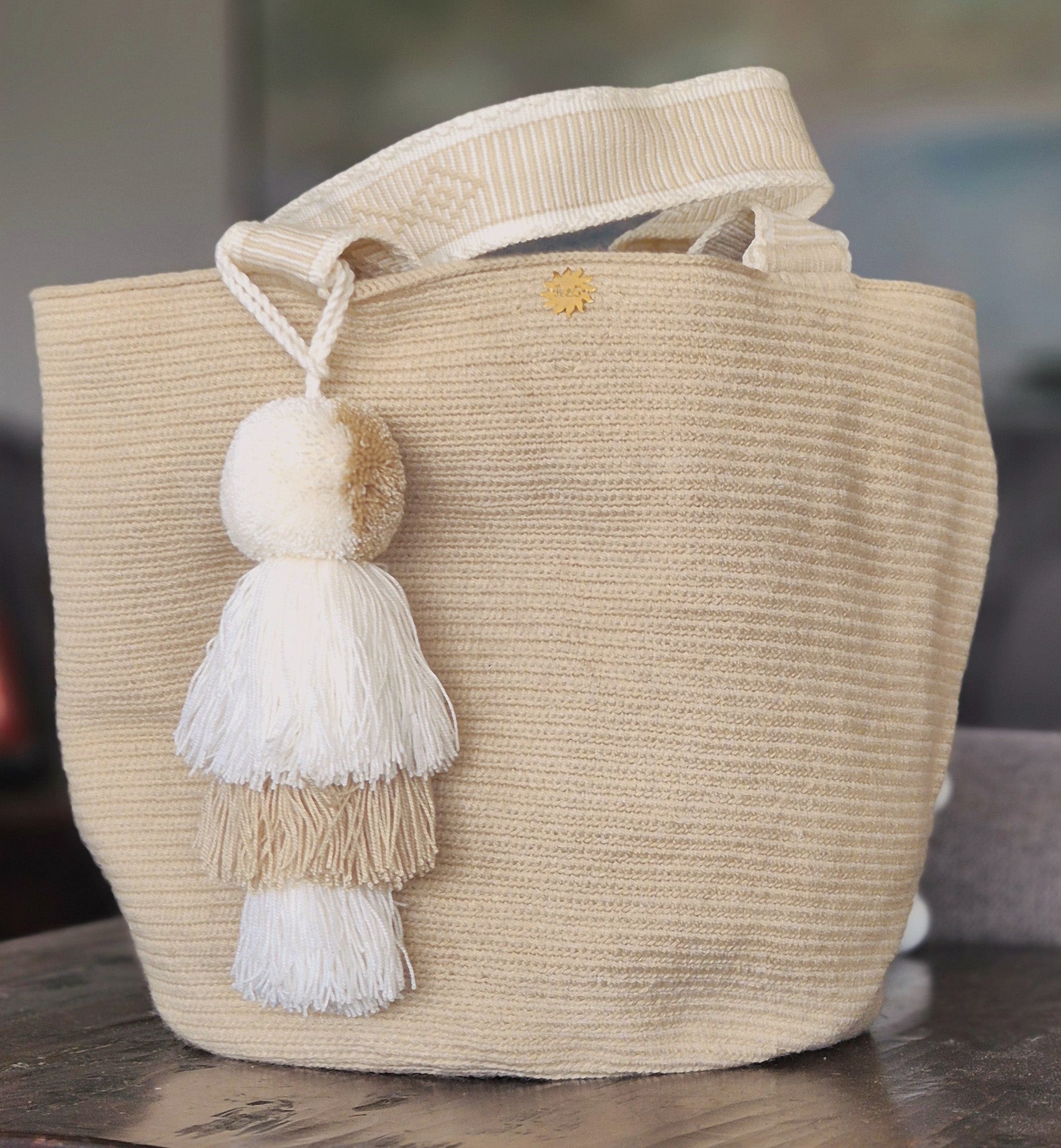 Beige handbag with handle and pompom in light beige and white