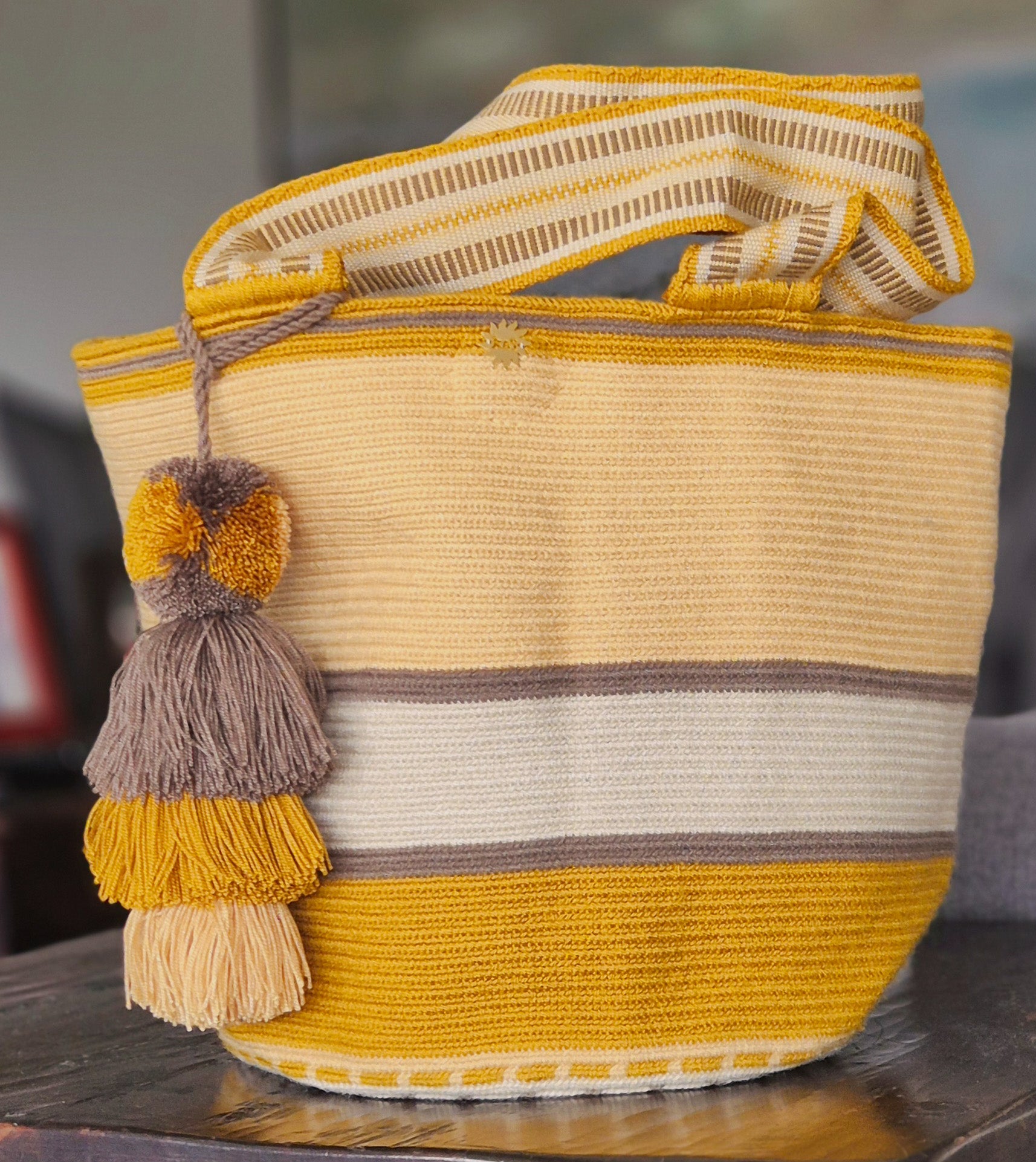 Mustard, beige, light yellow striped wallet with brown lines and handle and pompom in the same colors