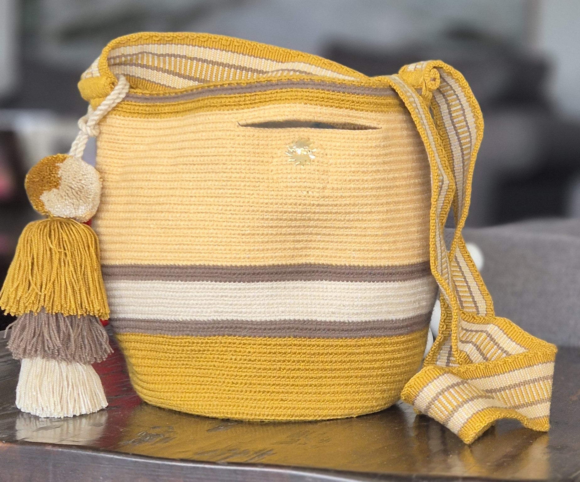 Brown, light yellow, mustard and beige striped wallet with handle and pompom in matching colors