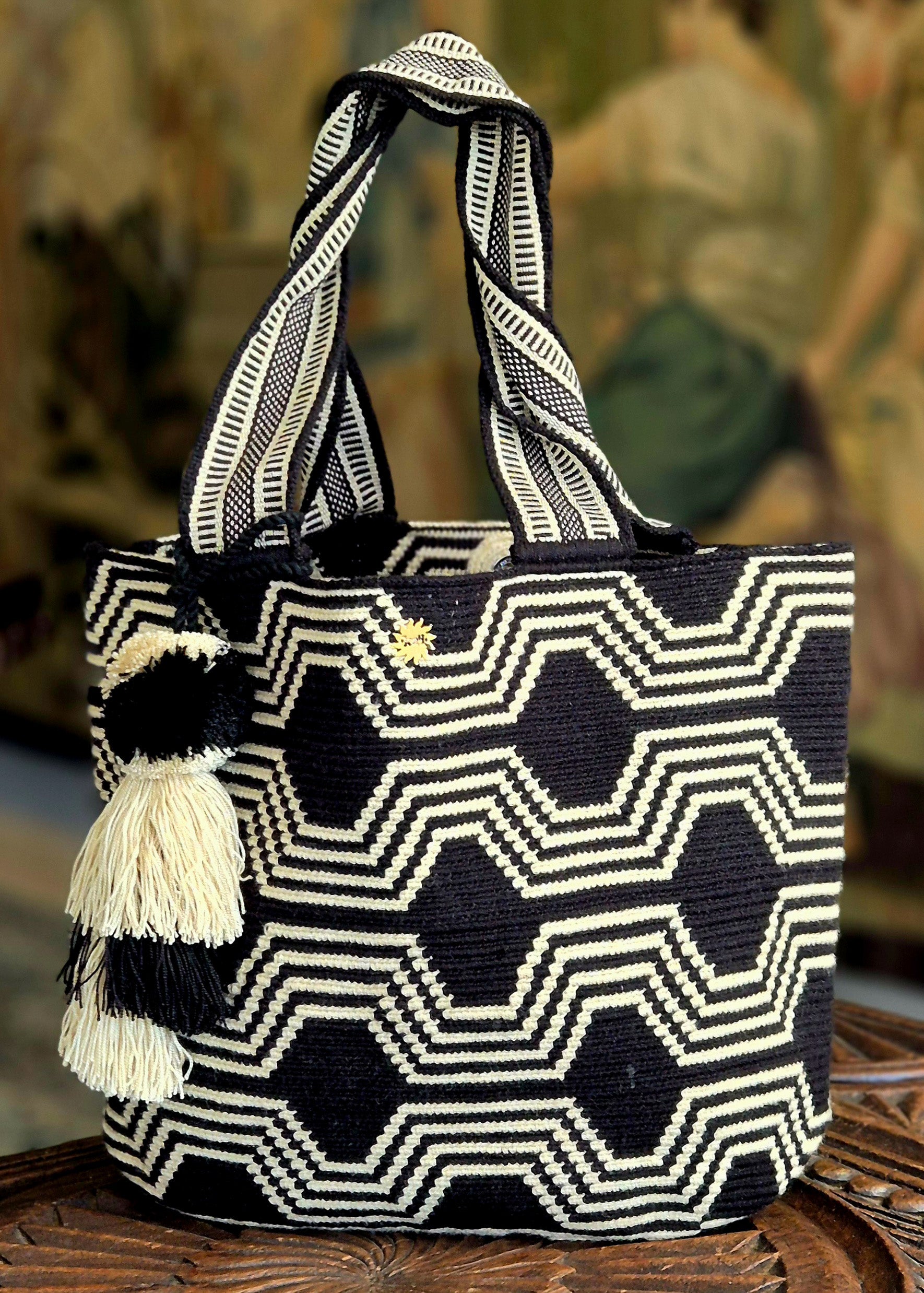 Cartera negra con patron de lineas beige continuas horizontal y diagonal